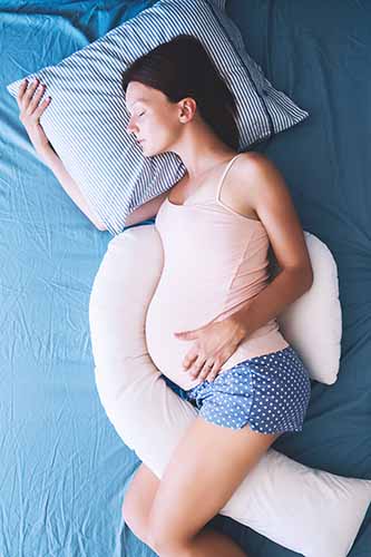 Pregnant Woman Sleeping with Body Pillow